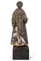 An antique carved and painted sculpture of a monk