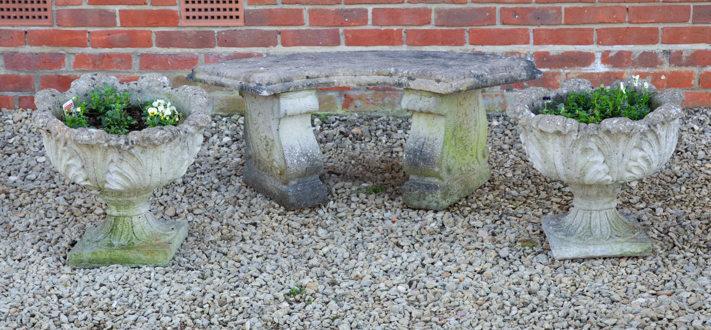 A pair of garden urns and a curved bench