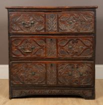 An antique carved elm chest of drawers