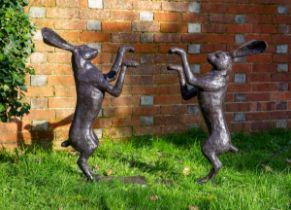 Two garden sculptures of bronze hares