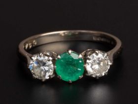 An emerald and diamond three stone ring