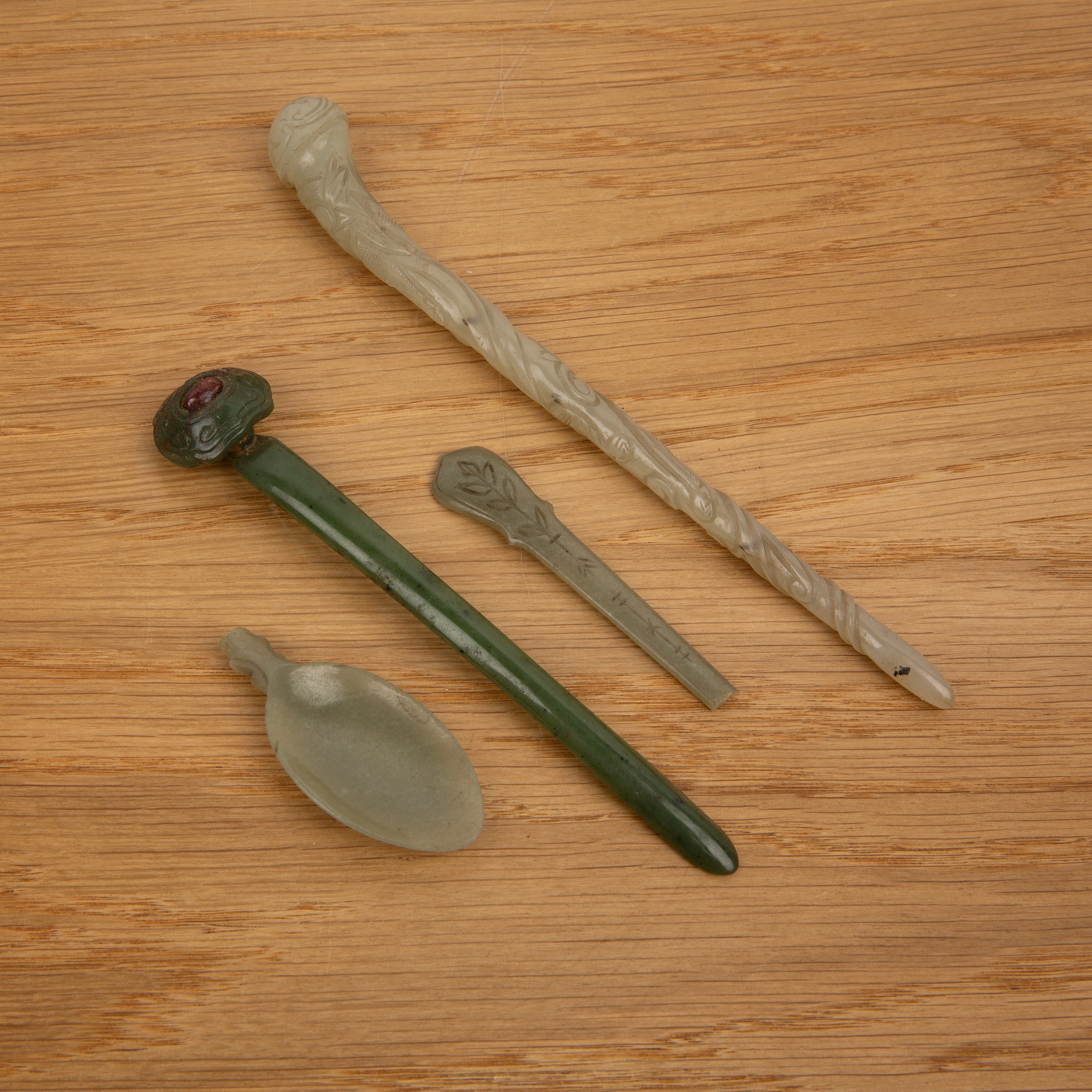 Two jade hairpins Chinese, 18th/19th Century including a pale green hairpin carved with a chi-long