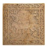Carved soapstone square tile panel Chinese decorated with a scaled dragon in flight to the centre,