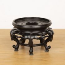 Hardwood stand Chinese, on five shaped supports, 18cm diameter x 12.5cm One leg is detached. With