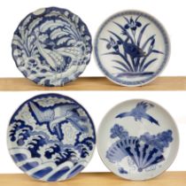 Four blue and white porcelain chargers Japanese variously painted with herons and other birds, the