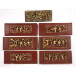 Seven temple carvings Chinese of red ground with gilt decoration, including temples and figures,