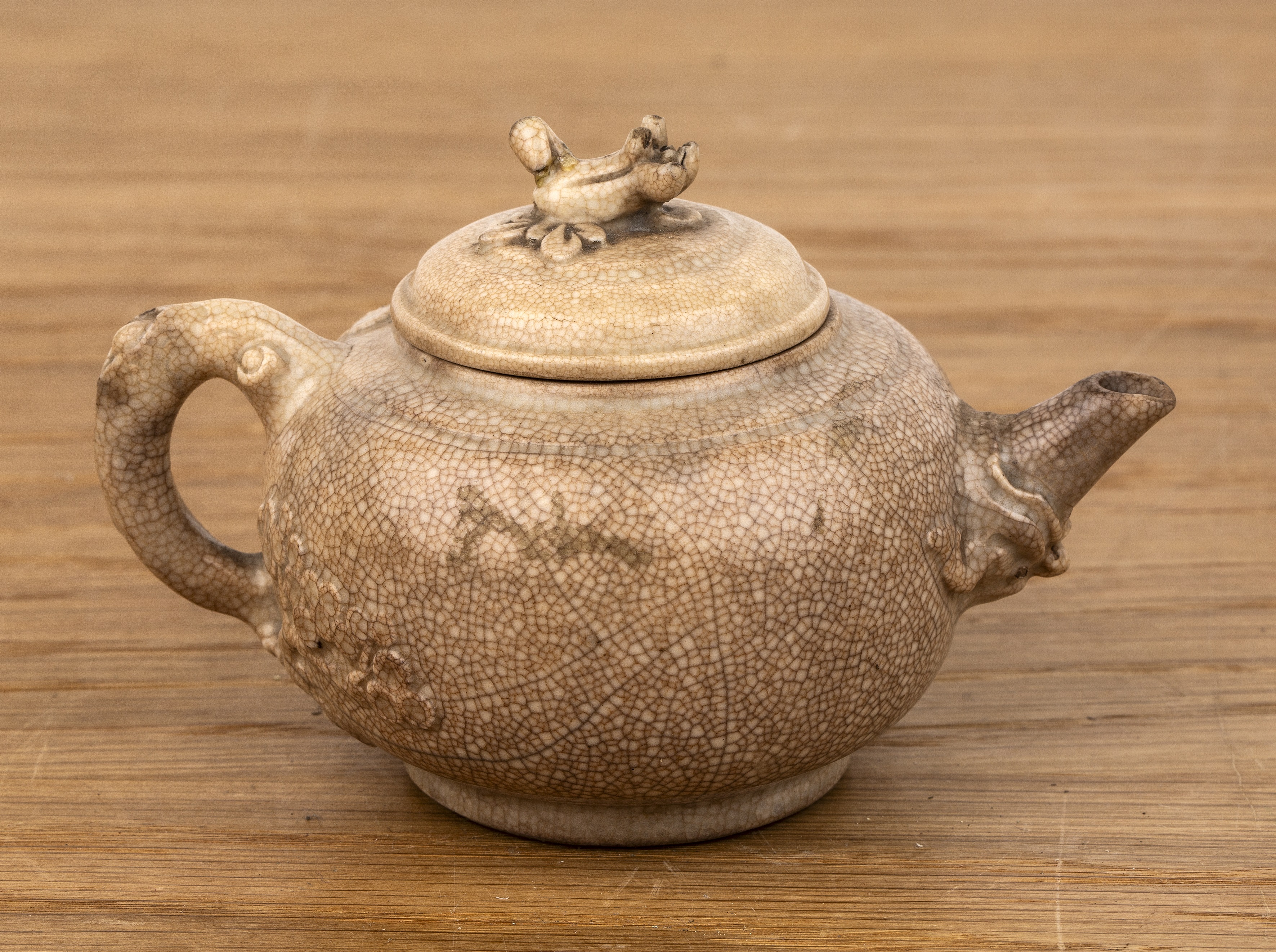 Small white glazed teapot Chinese, 18th Century with a bocage handle and leaf finial, 12cm long