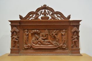 Hardwood arched panel Indian carved with a recumbent Shiva and further acolytes, 60cm x 84cm overall