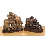 Two soapstone carvings Chinese each with a carved wood stand, 26cm and 19cm high (2) Both with