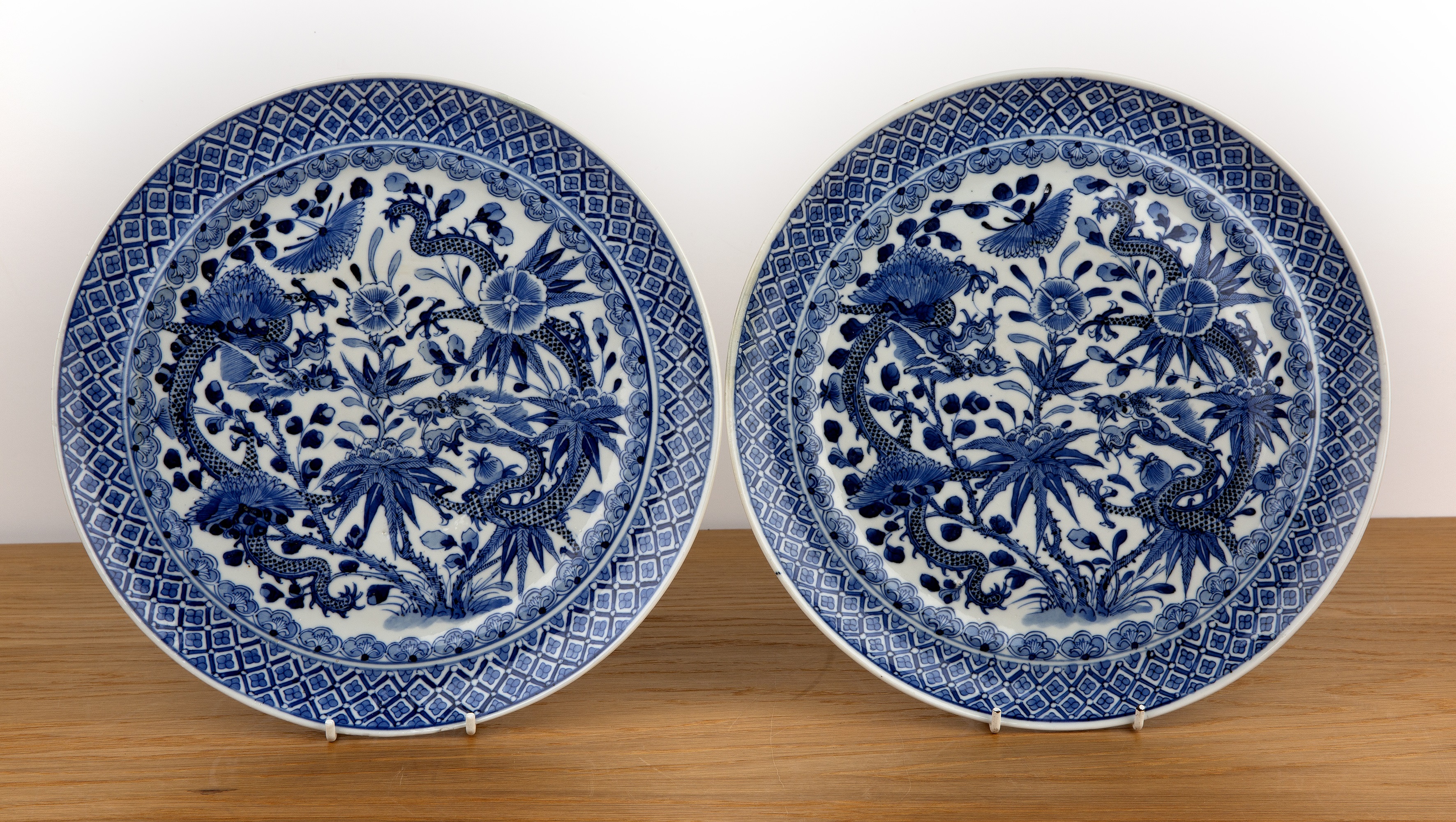 Pair of blue and white porcelain plates Chinese, 19th Century painted with dragons, amongst lotus