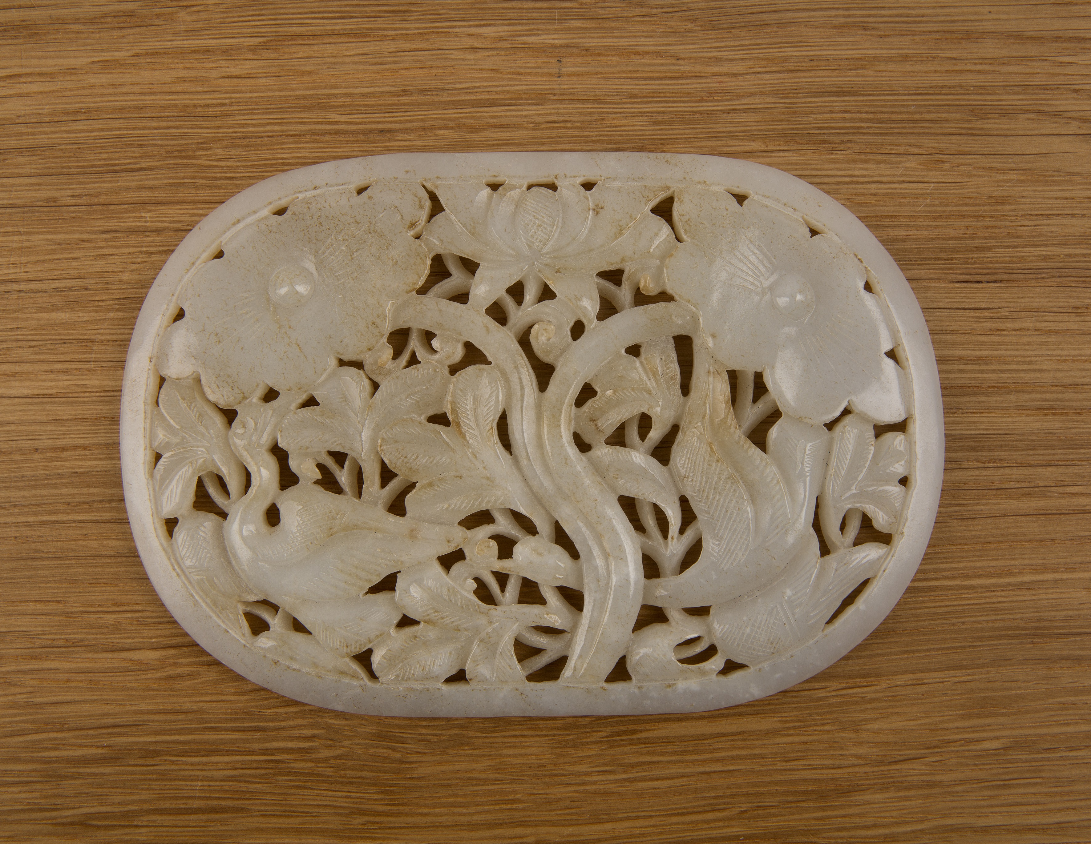 Oval jade plaque Chinese carved with herons and lotus flowers, 14cm x 10cm With some wear,