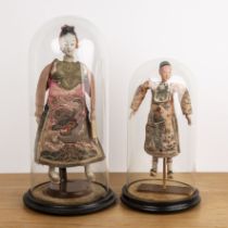 Two wooden dolls under glass domes Chinese to include a male doll, in a peach ground gown, the
