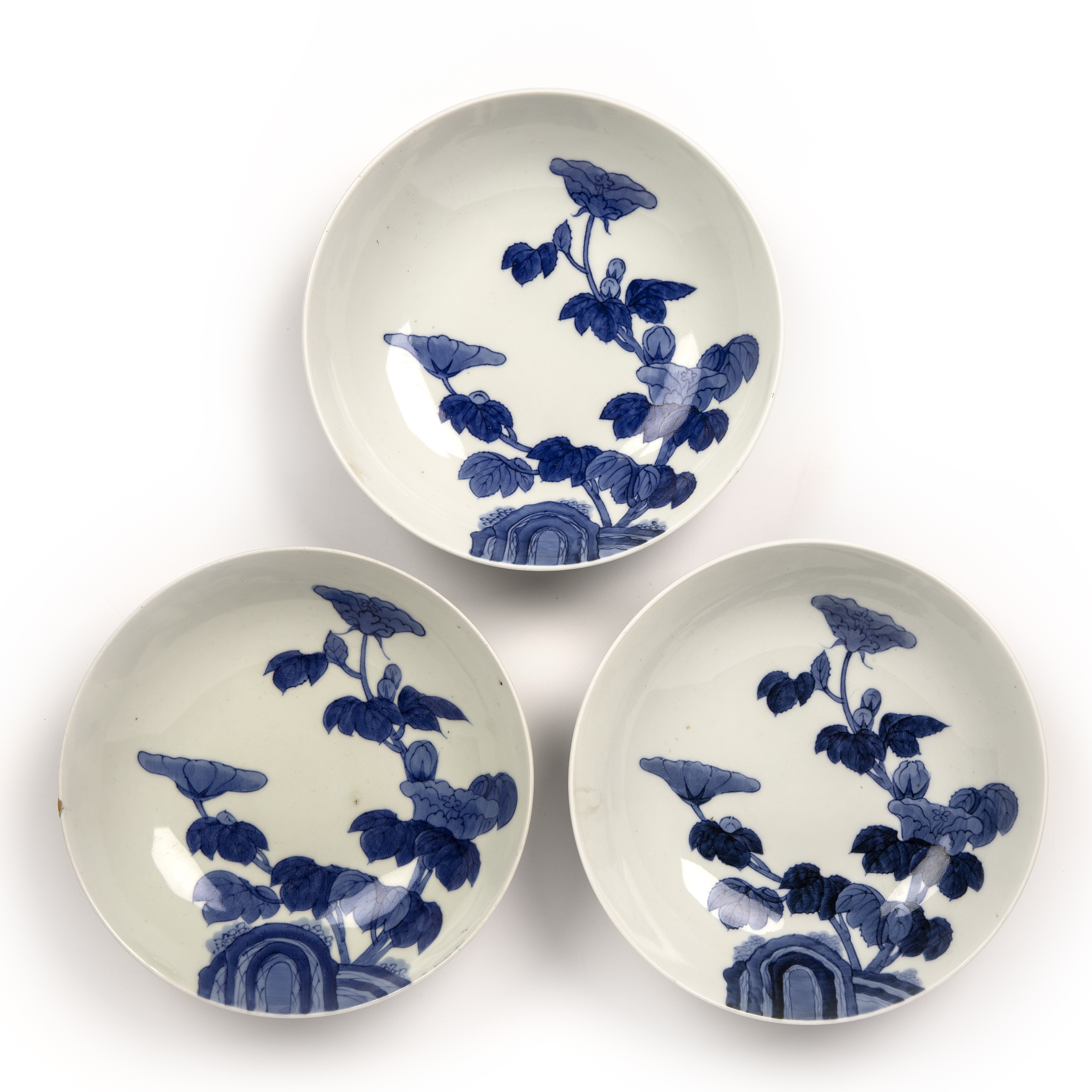 Three Hirado blue and white bowls Japanese, 19th Century painted with flowers and rock work, 20.