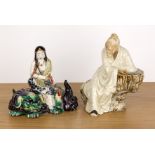 Two porcelain figures Chinese and Japanese including a seated Shiwan glazed scholar leaning