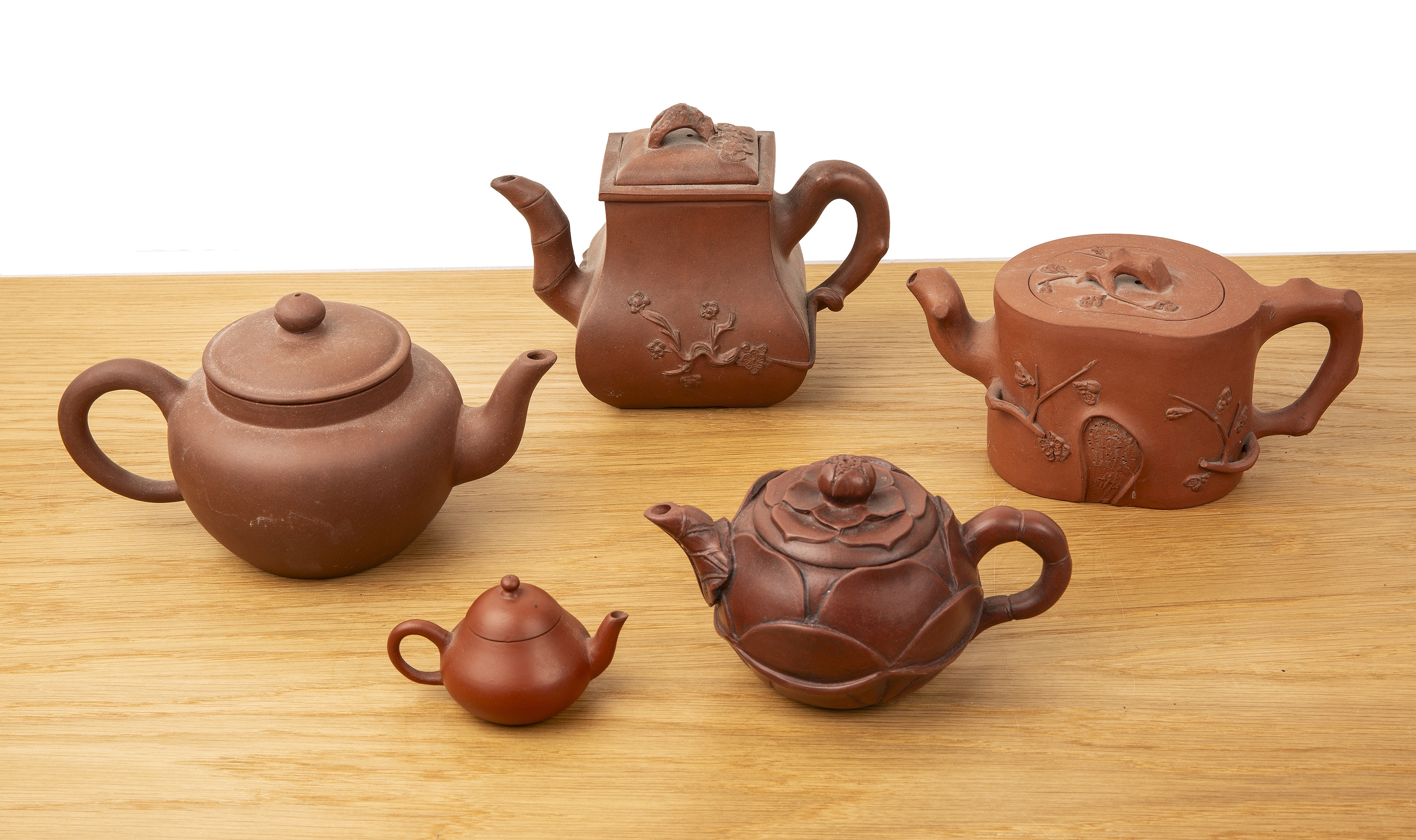 Group of five Yixing teapots Chinese, 19th/20th Century to include a rectangular teapot with moulded