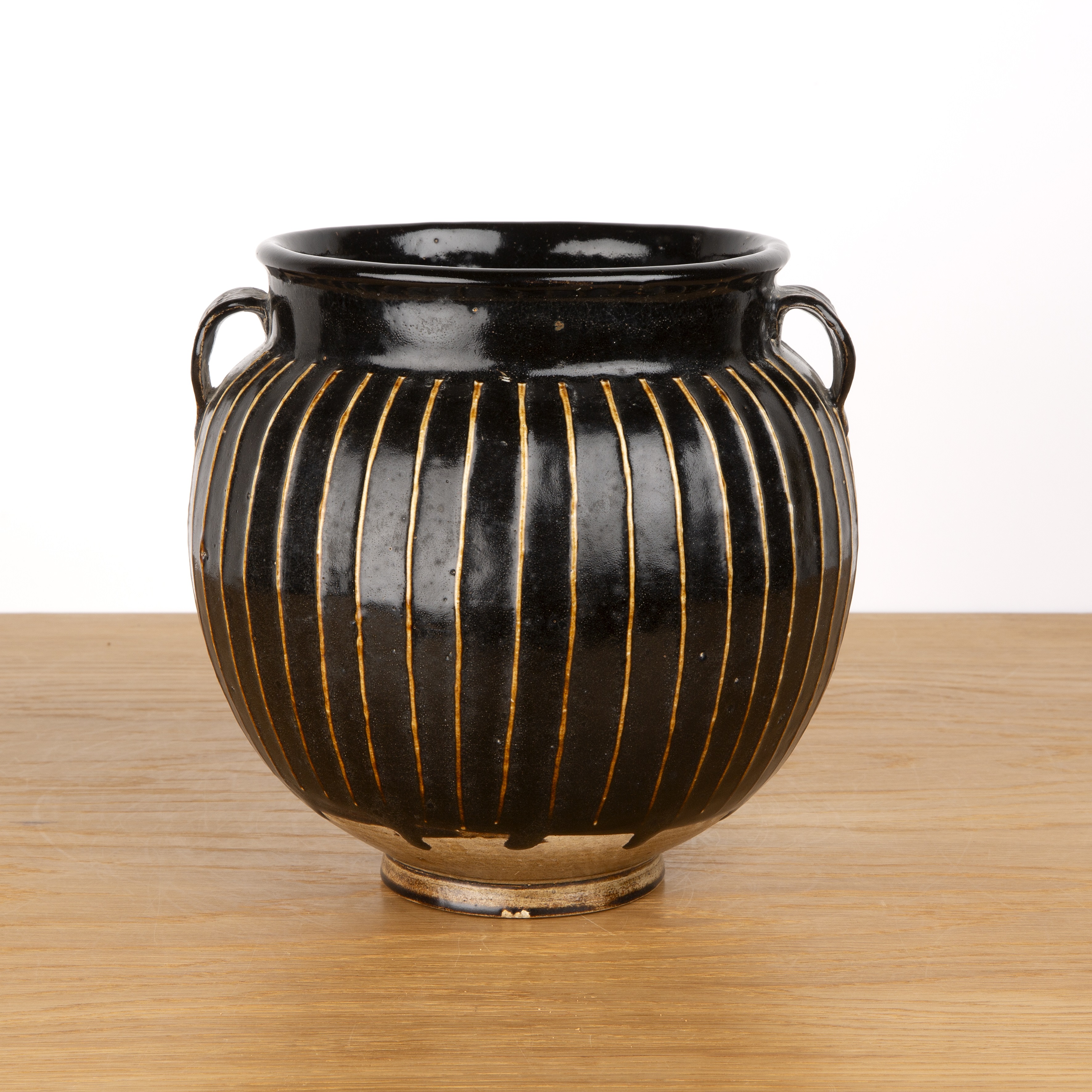 Treacle glazed two handled vase Chinese, 19th Century of reeded form with a raised foot, 22cm high