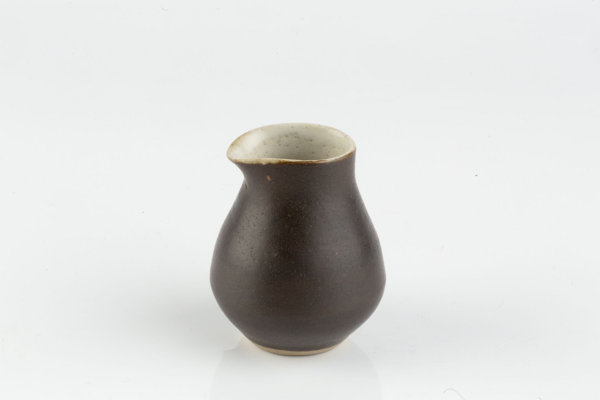 Lucie Rie (1902-1995) Miniature pourer manganese glaze impressed potter's seal 5.8cm high.