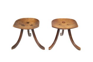 Liberty & Co. A pair of Thebes stools, circa 1910 oak, each with a dish seat over three swept legs