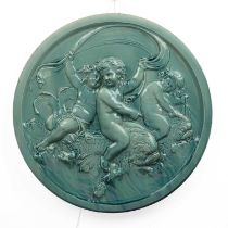 Turquoise glazed roundel 19th Century, decorated in relief with cherubs/putti riding scaled fish,