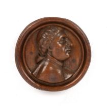 An 18th century carved oak relief roundel depicting and head and shoulder portrait 22cm diameter.