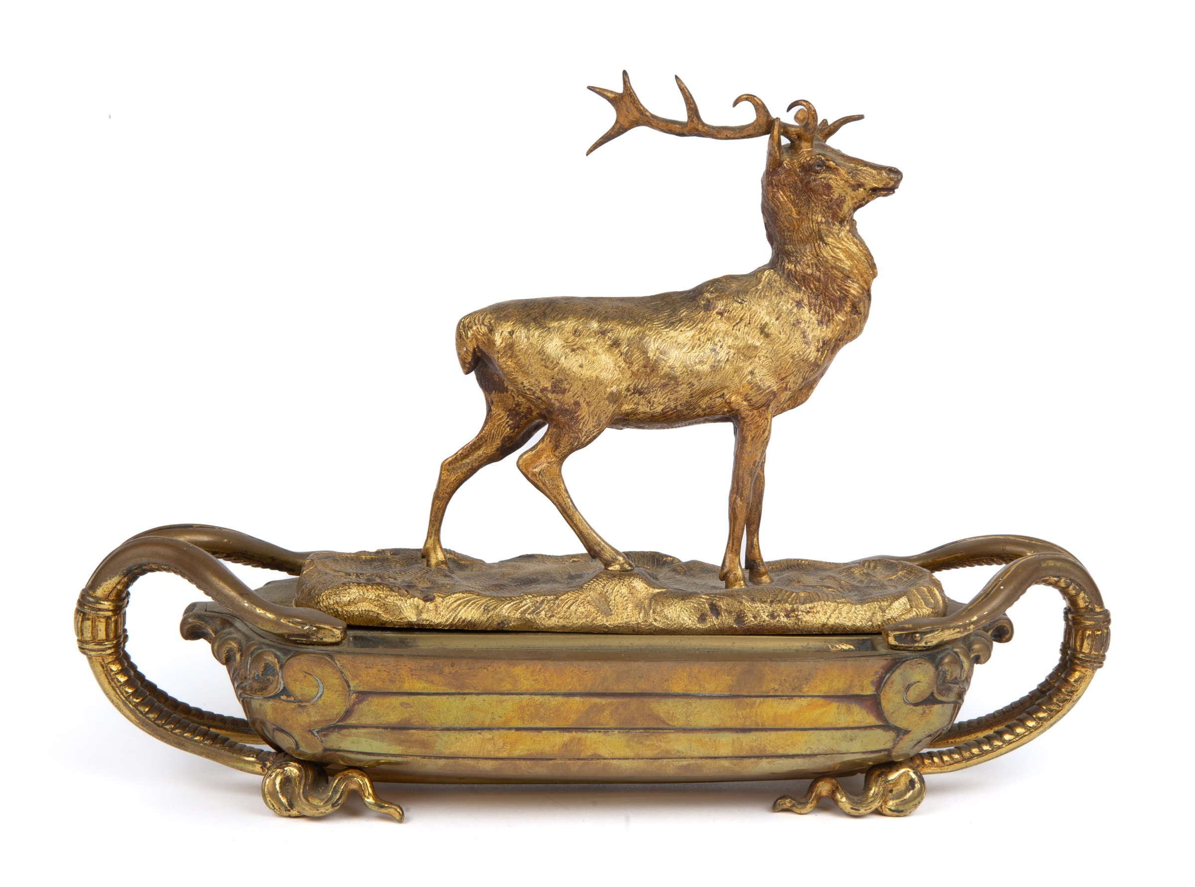 A 19th century gilt metal inkstand with a stag surmount on a boat-shaped base and with serpent