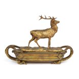 A 19th century gilt metal inkstand with a stag surmount on a boat-shaped base and with serpent
