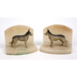 A pair of alabaster and spelter book ends in the form of German shepherd dogs each 15cm wide