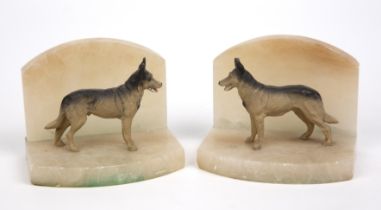 A pair of alabaster and spelter book ends in the form of German shepherd dogs each 15cm wide