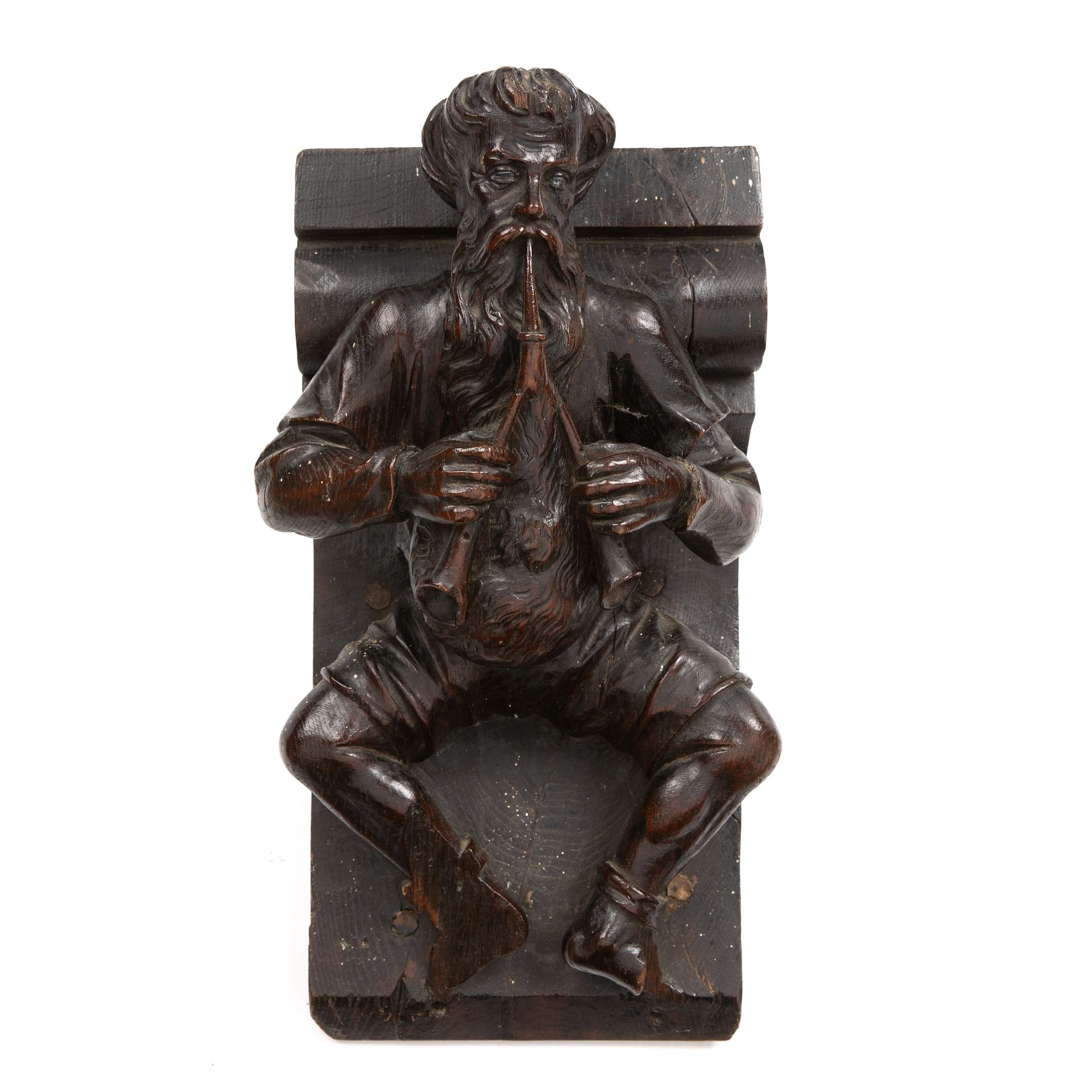 An 18th/19th century carved oak bracket in the form of a medieval bag piper 23cm wide 26vcm deep