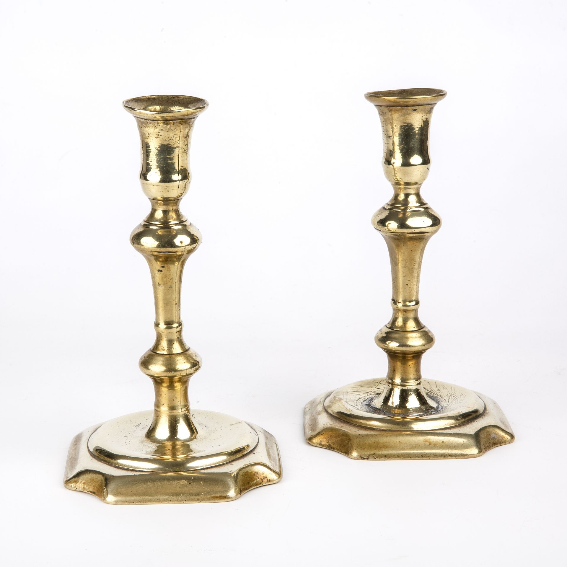 A pair of George II brass candlesticks circa 1740, 10cm wide 18cm high Restoration to one.