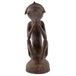 An African carved tribal seated figure 12cm wide 33cm high