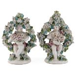 A pair late 18th century possibly Derby flower encrusted cherubs 13cm wide 19cm high Cherub with