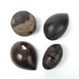 Four antique tribal nuts, two with engraved decoration, the largest 14cm high