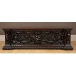 An Italian walnut cassone with a figurally carved fall front. 145cm wide x 51cm deep x 45cm high