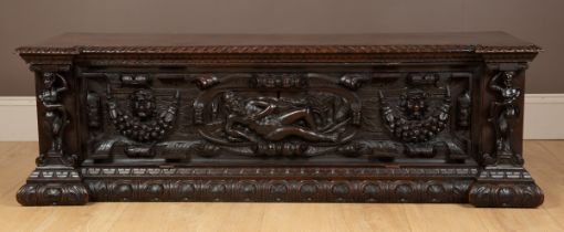 An Italian walnut cassone with a figurally carved fall front. 145cm wide x 51cm deep x 45cm high