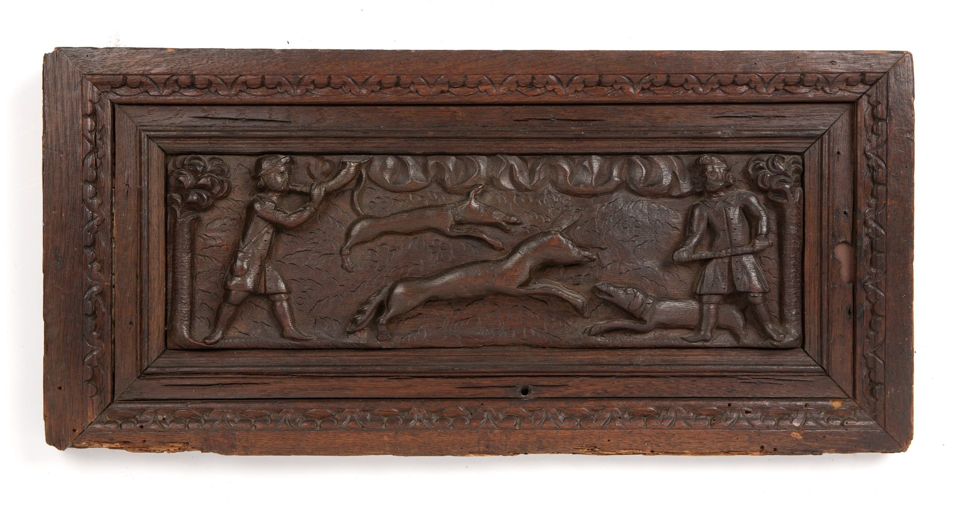 An antique possibly Flemish carved oak hunting scene mounted in carved oak frame overall 28cm x 61cm