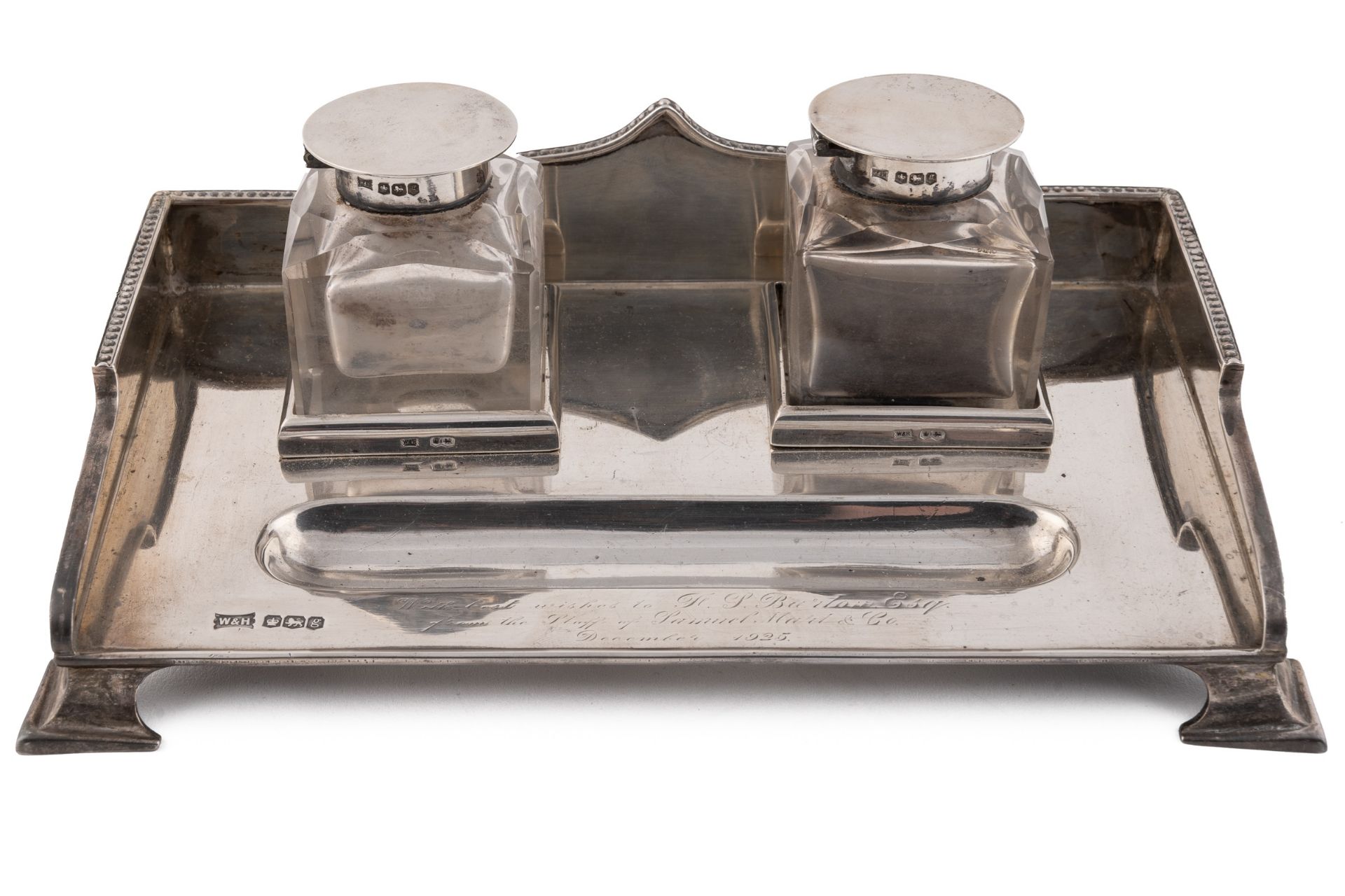 A George V silver inkstand, with shaped and beaded gallery, fitted with a pair of square section cut