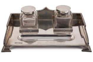 A George V silver inkstand, with shaped and beaded gallery, fitted with a pair of square section cut