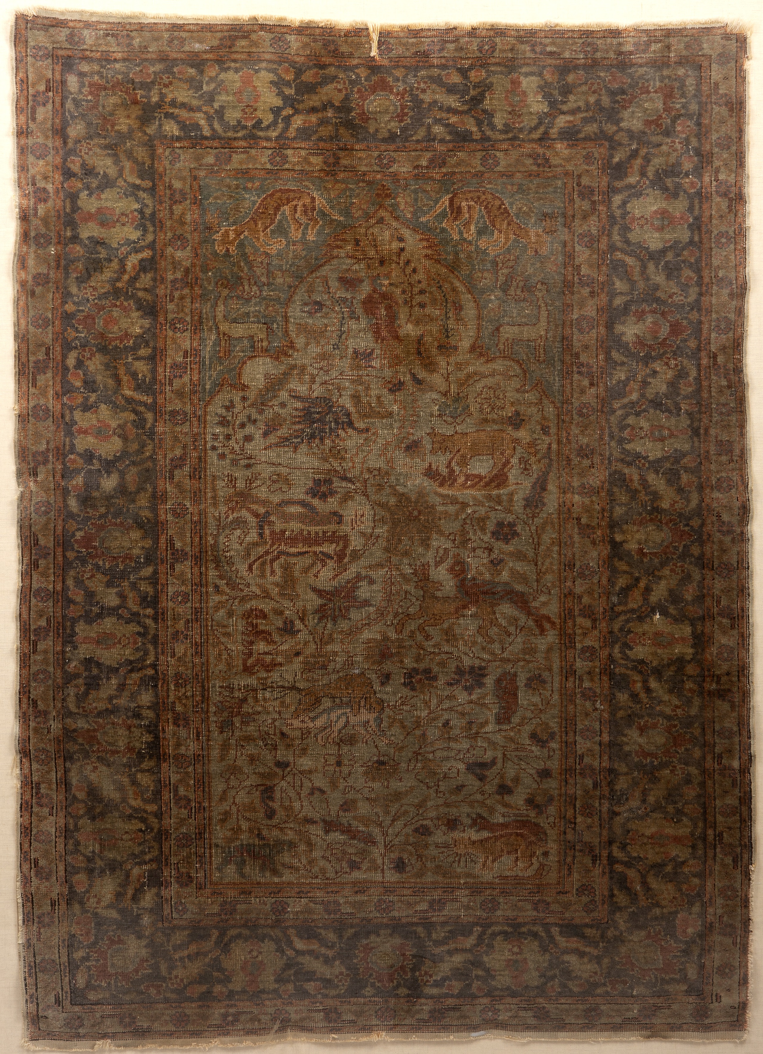 An antique Persian rug decorated with flora and fauna 80cm x 110cm