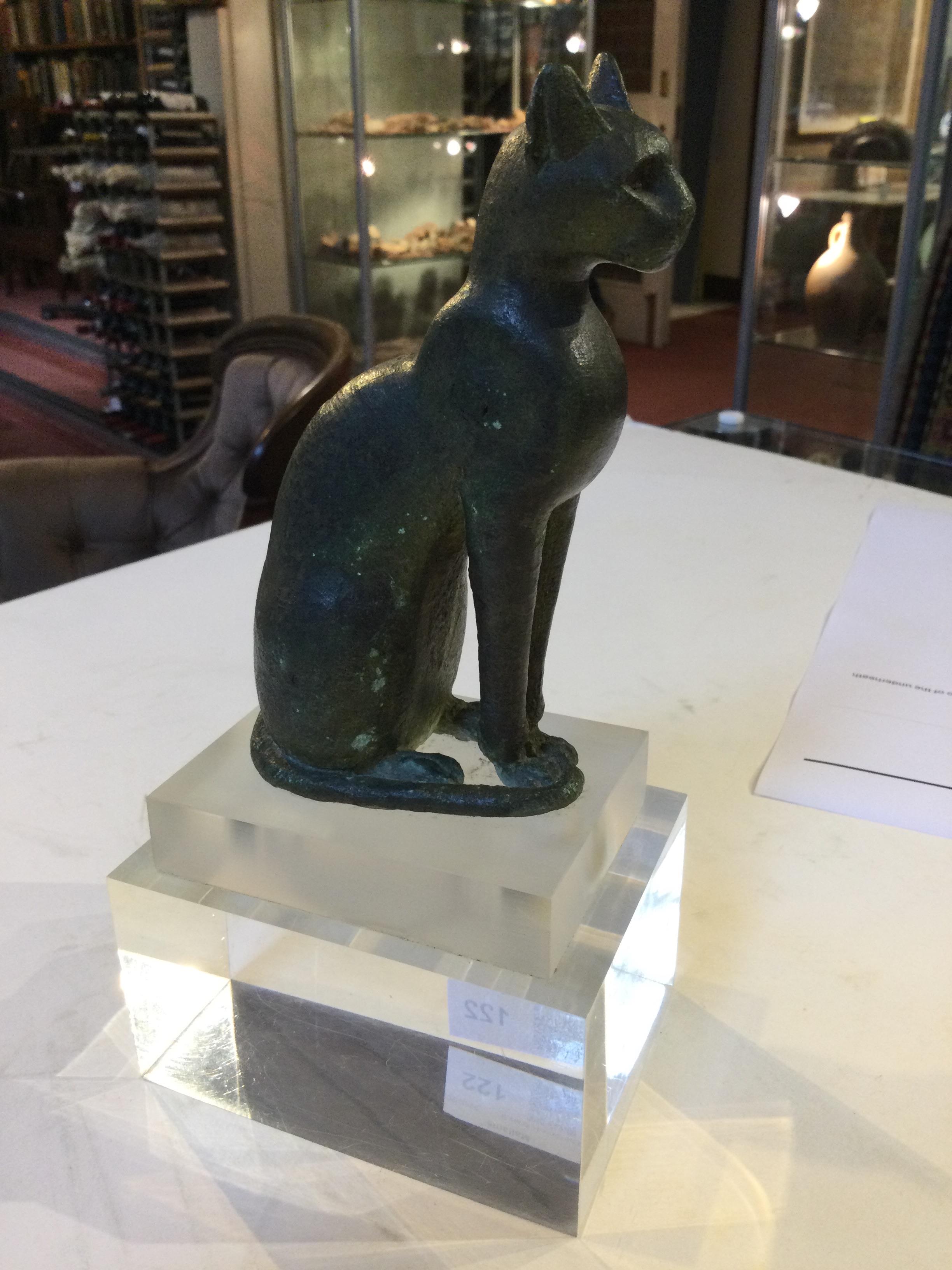 An Egyptian bronze cat figure , hollow cast, depicted seated and alert with forepaws together and - Image 9 of 26
