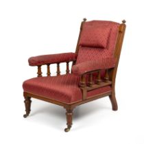 A Victorian oak upholstered armchair the open arms with turned supports and having turned front legs