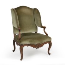 A Louis XVI style wing back upholstered armchair with a carved oak frame 75cm wide