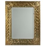 An arts and crafts pressed brass framed wall mirror with bevelled glass 38.5cm x 49cm