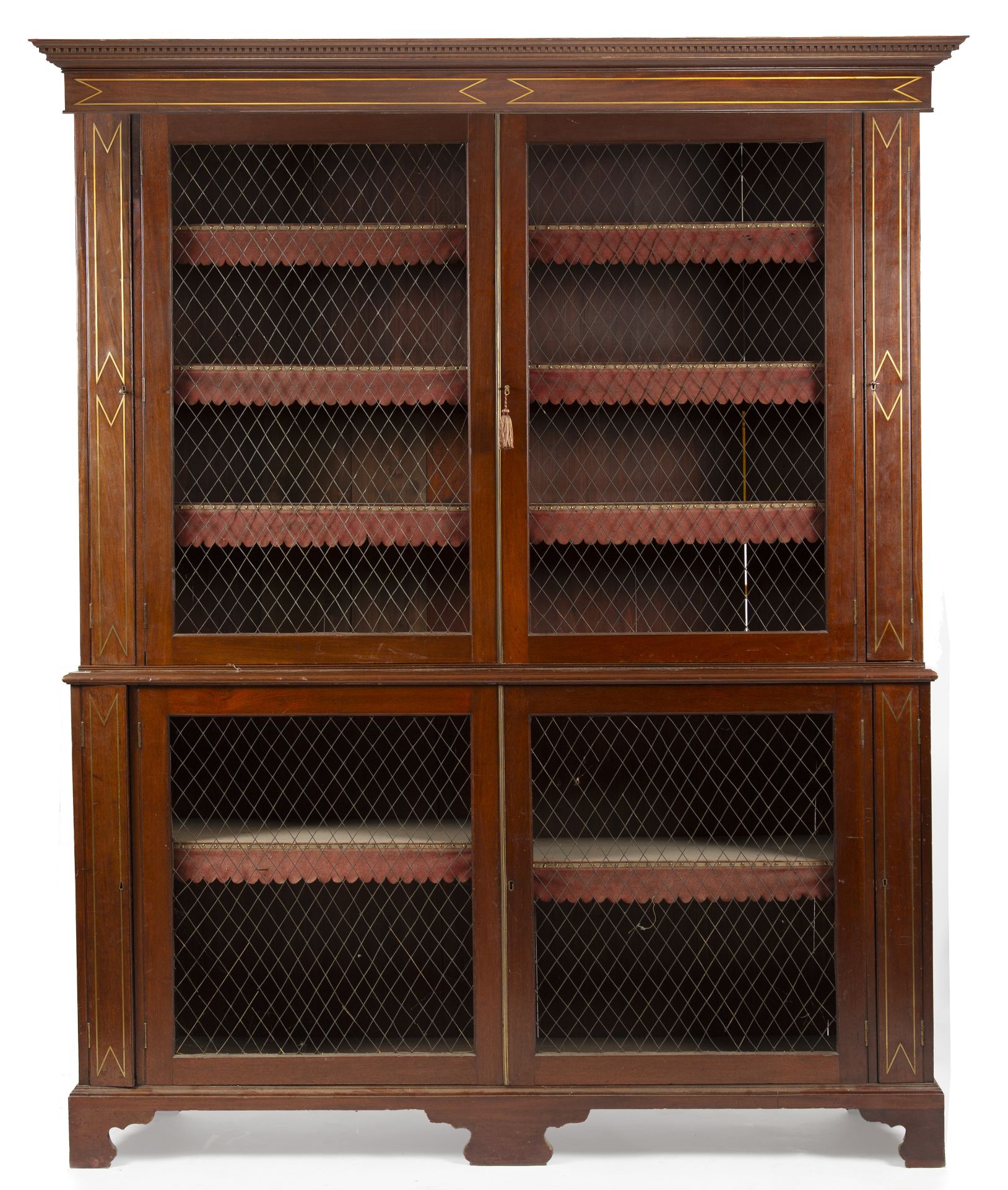 A Regency mahogany brass inlaid bookcase with adjustable shelves and wirework doors, all raised on