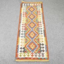 A kilim runner, with a row of five central hooked medallions, 206 x 66cm