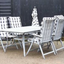 A metal garden set, comprising a table and four folding garden chairs, with cushions, parasol and