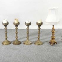 A set of four ornate brass pricket candlesticks, each 46cm high, together with a gilt table lamp and