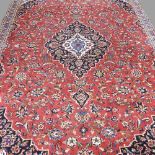 A Persian kashan carpet, with all over floral designs, on a red ground, 320 x 220cm