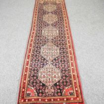 A Persian runner, with a row of five ivory coloured medallions, 250 x 70cm