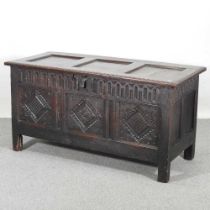 An 18th century carved oak coffer, with a hinged lid and panelled front 138w x 59d x 71h cm